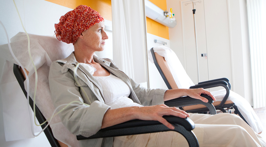 woman seated and receiving cancer medication