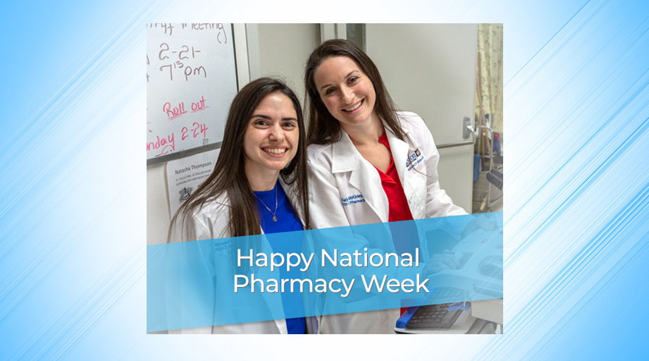 two smiling female pharmacists with banner - Happy National Pharmacy Week