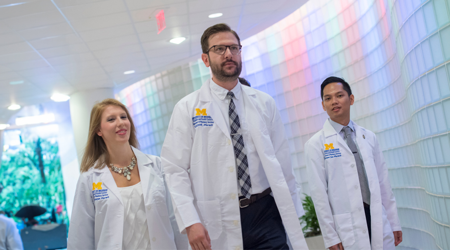 two male and one female pharmacists walking 