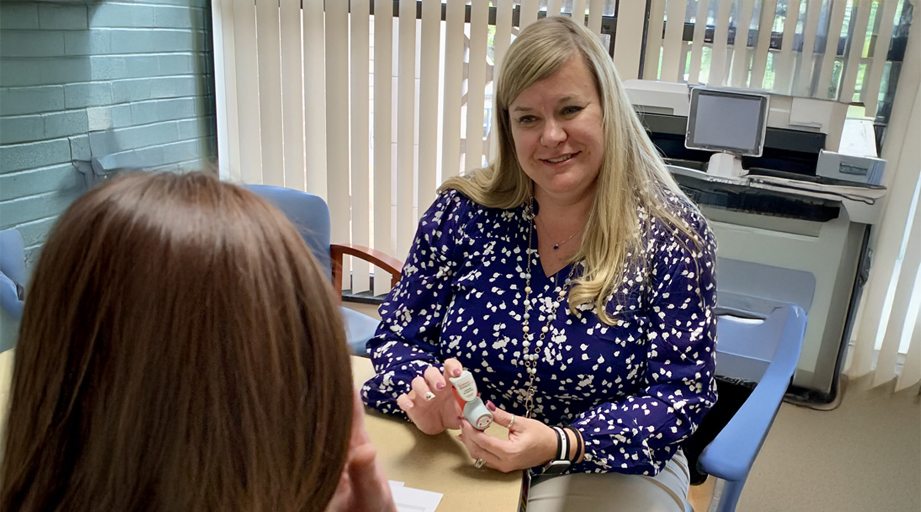 female pharmacist going over medication with female patient