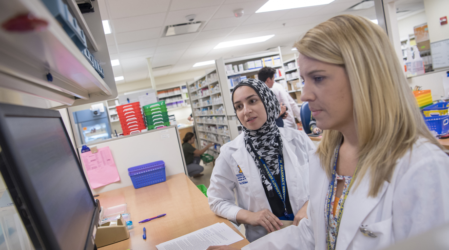 two female pharmacists looking at a computer monitor