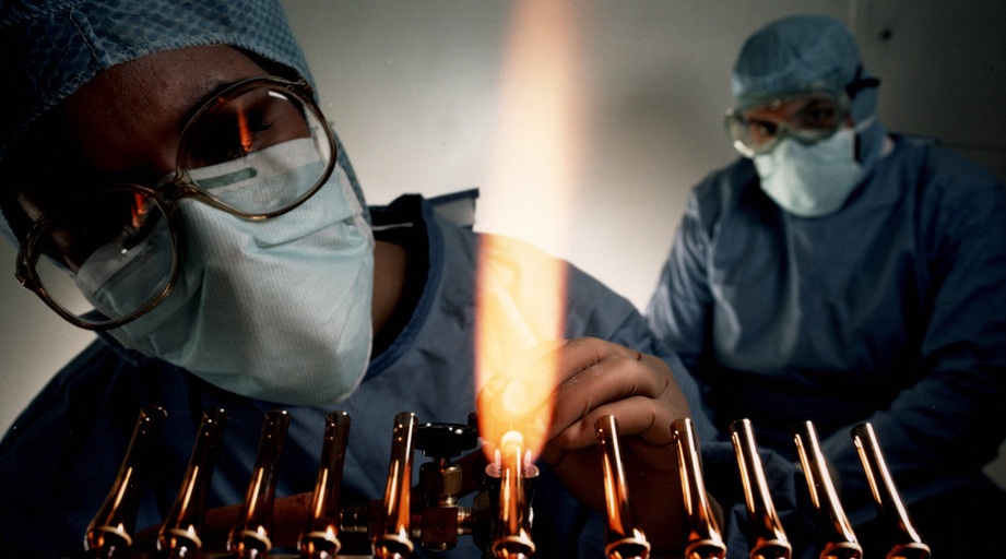 NIH pharmacists seal glass ampuls at the Clinical Center (1984).