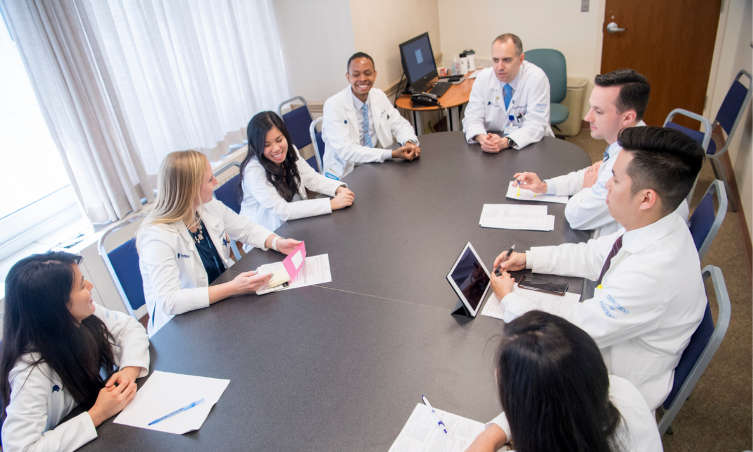 healthcare providers sitting around a conference table discussing topics