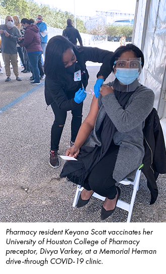 Pharmacy resident Keyana Scott vaccinates her University of Houston College of Pharmacy preceptor, Divya Varkey, at a Memorial Herman drive-through COVID-19 clinic.